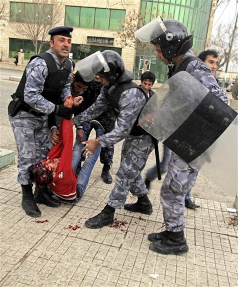 Iraqi riot police officers carry the body of a protester in front of the headquarters of Kurdish President Massoud Barzani's political party in Sulaimaniyah, 260 kilometers  northeast of Baghdad, Iraq, on Thursday, Feb. 17. Kurdish security forces opened fire on a crowd of protesters surrounding the headquarters of the party affiliated with the Kurdish president. 